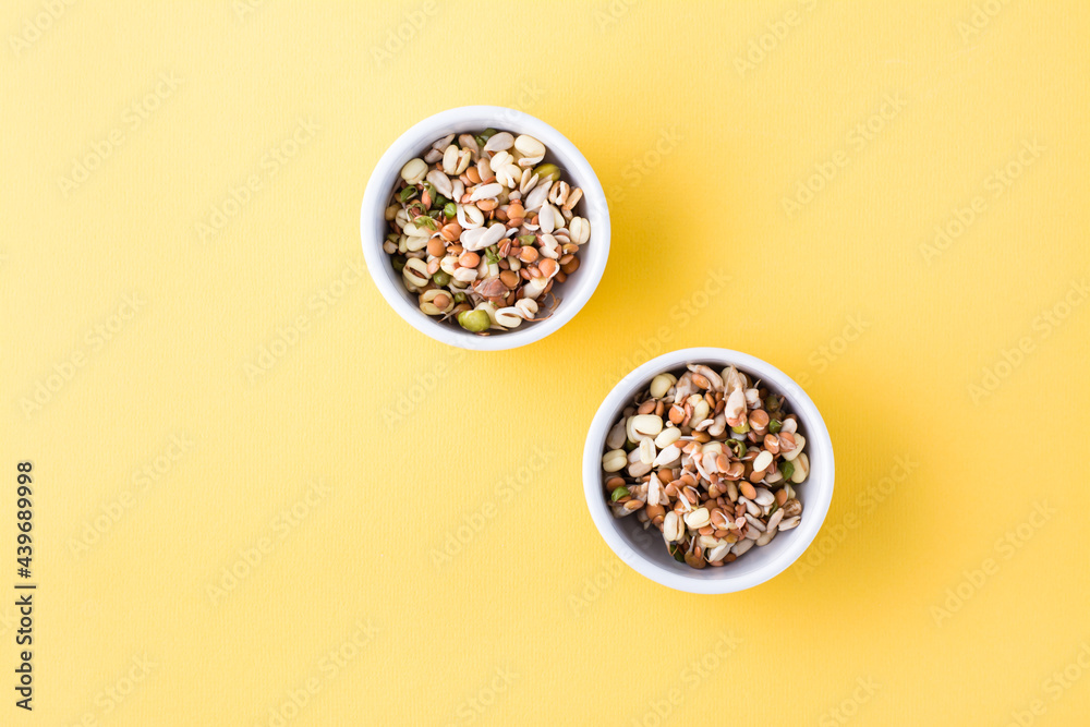 Sprouted grains of mung beans, lentils, flax and sunflowers in bowls on a yellow background. Top view. Copy space Sprouted grains of mung beans, lentils, flax and sunflowers in bowls on a yellow background. Top view. Copy space