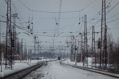 Winter Railway tracks with burning semaphores and a web of wires above them
