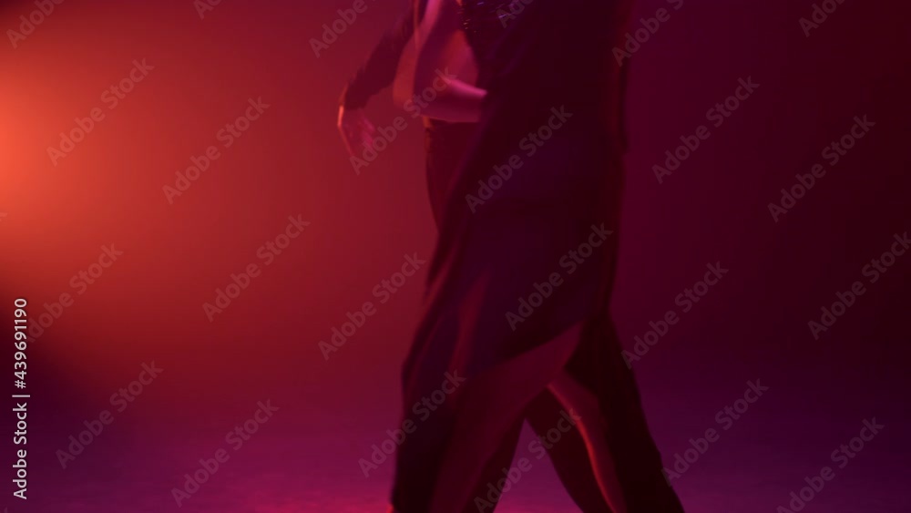 Dancers body moving in dark background. Unknown couple dancing rumba indoors.