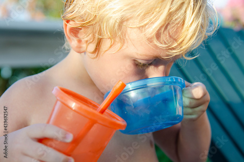 Young boy having a drink and a snack in summer, outside