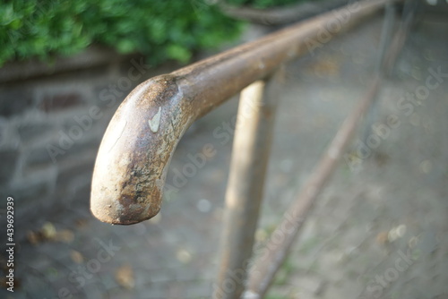 Handlauf an einem Fußweg mit Treppenstufen aus altem, abgenutzten Eisen © darknightsky