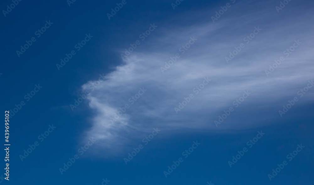 Blue, beautiful sky background. Oddly shaped clouds in a blue sky