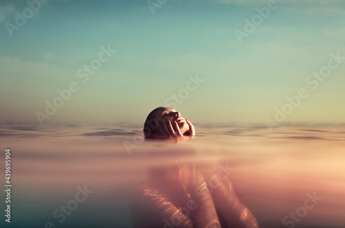 Woman holding touching her face in the water photo