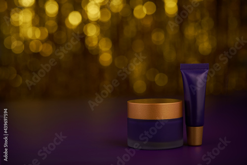 Natural night face cream or lotion on shiny gold glittering background.