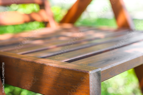 Wooden furniture made by hand outdoors close-up. A chair made of wood. Garden furniture among plants. photo