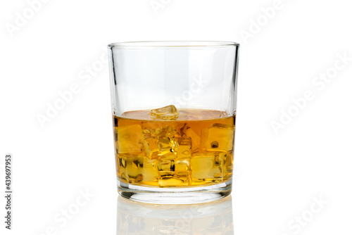 Glass of whiskey or whisky or american Kentucky bourbon with ice cubes with its reflection on the plan. isolated on white