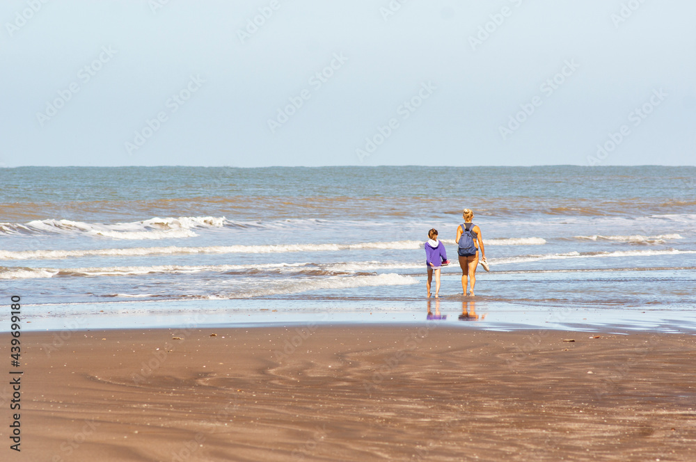 mother and daughter walking quietly on the beach