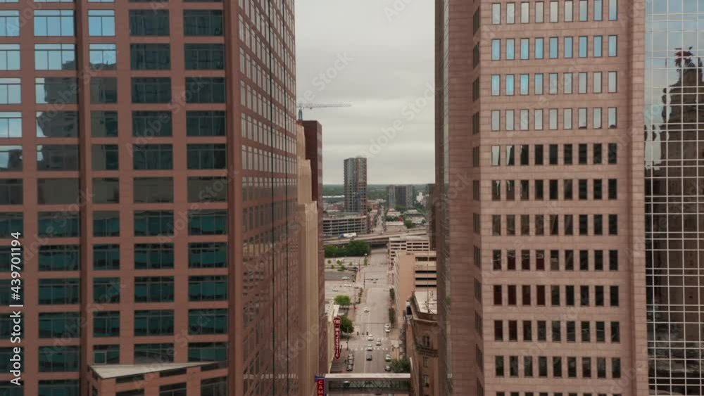 Aerial view of downtown. Drone flying above street between two modern skyscrapers. Revealing view on highway and construction site. Dallas, Texas, US