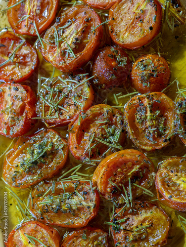 cherry tomatoes cut in halves seasoned with oil, rosemary and bl