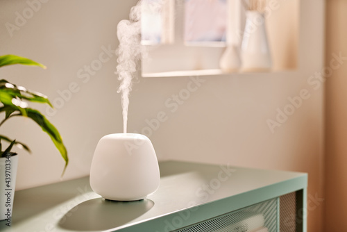 Modern humidifier on table in morning photo