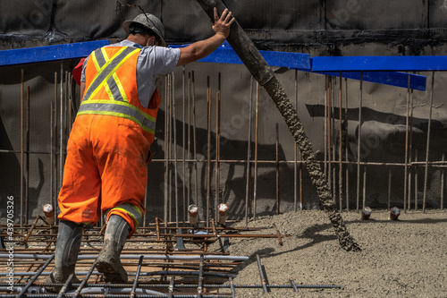 Worker Pours Concrete On Construction Site