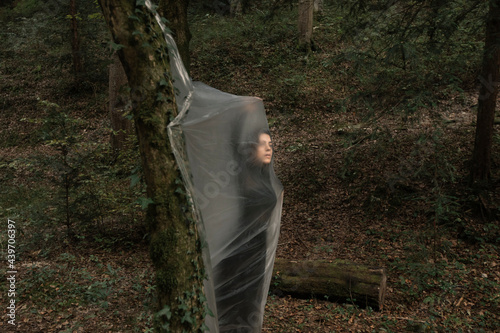 Young Woman Dancing In The Forest And Trapped In A Plastic Sheet