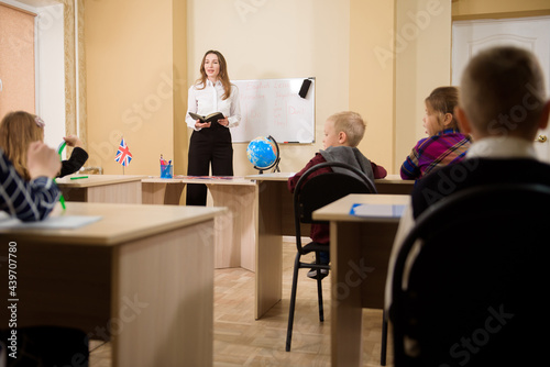 Teacher teaching lesson to elementary school pupils.