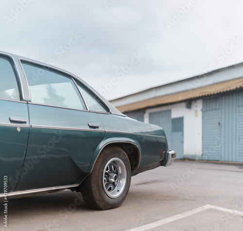 Back of a classic car parked near the garage photo