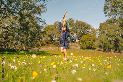 Little girl enjoying with her rhythmic gymnastics ribbon in spring photo