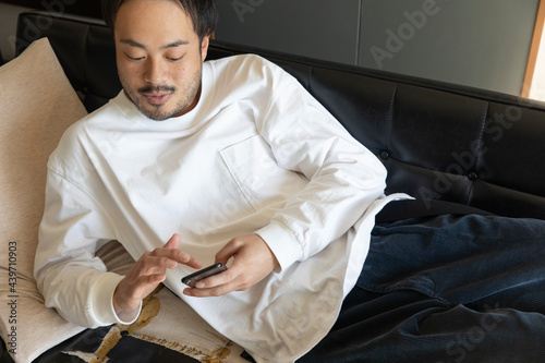 Men spending the relax holiday on the sofa with smartphone