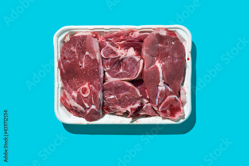 raw lamb meat cuts in a white foam tray photo