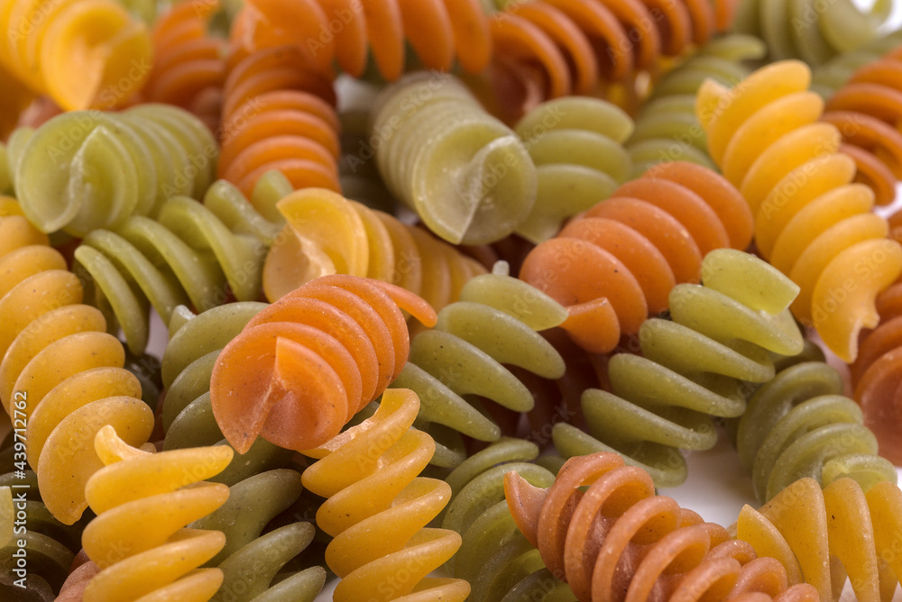 Close-up of dry pasta in the form of multi-colored corkscrew (Fusilli). Close-up of dry pasta in the form of multi-colored corkscrew (Fusilli).