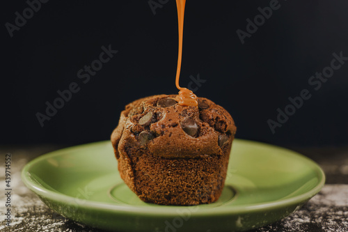 Homemade chocolate chips muffin with caramel on a green dish served gourmet