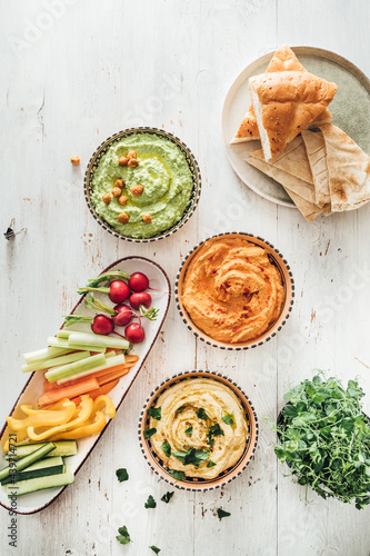 Food: different styles of hummus and vegetables photo