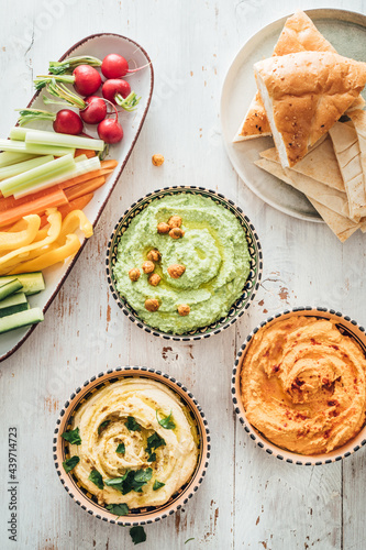 Food: different styles of hummus and vegetables photo