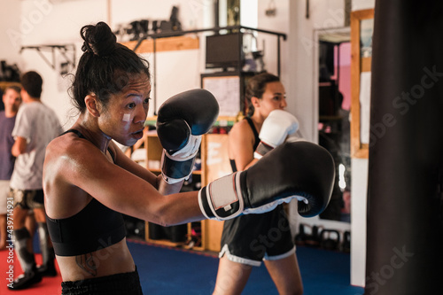 Thai Female Muay Thai Athlete Practicing On The Heavy Bag