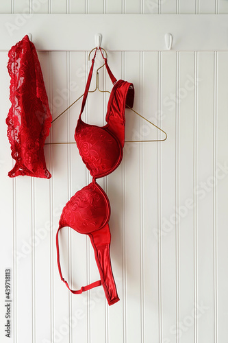 Red lace bras and panties hanging on hooks 