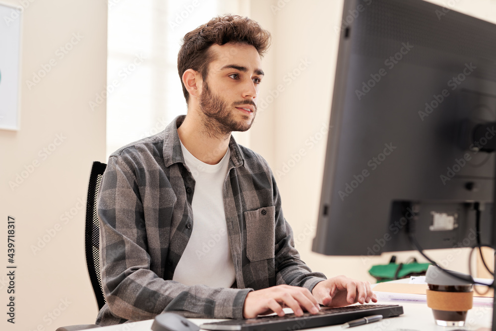 Focused male freelancer browsing computer Focused male freelancer browsing computer