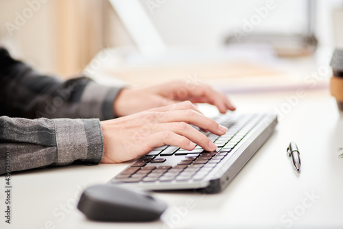 Crop male employee typing on computer keyboard photo