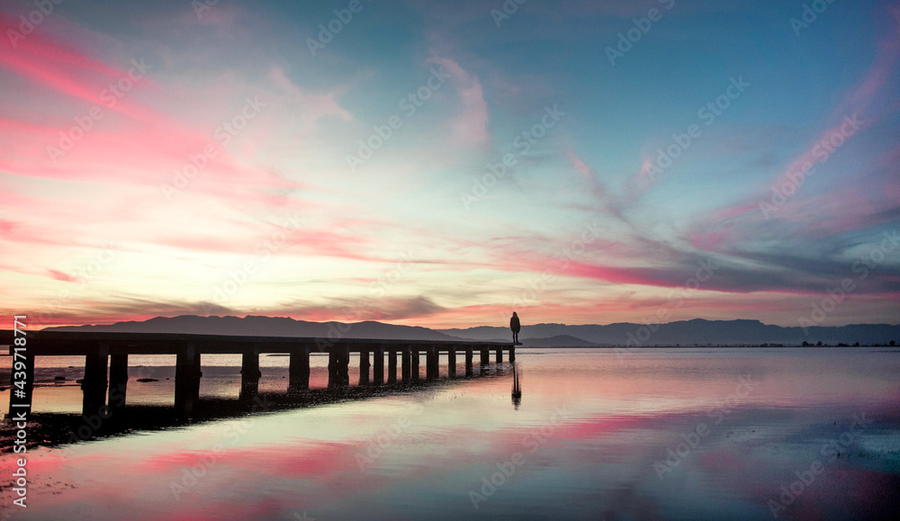 Distant human silhouette standing at the dock Distant human silhouette standing at the dock