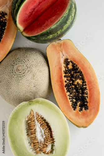 Half cut fruit and summery melons on a white table