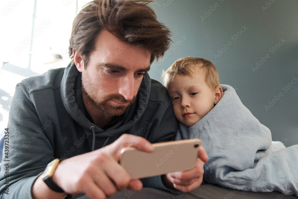 Father and son watching cartoons on the phone Father and son watching cartoons on the phone