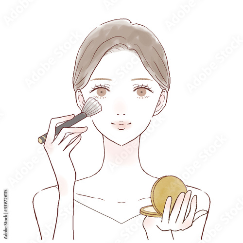 パウダリーファンデーションをメイクブラシで顔に塗る女性