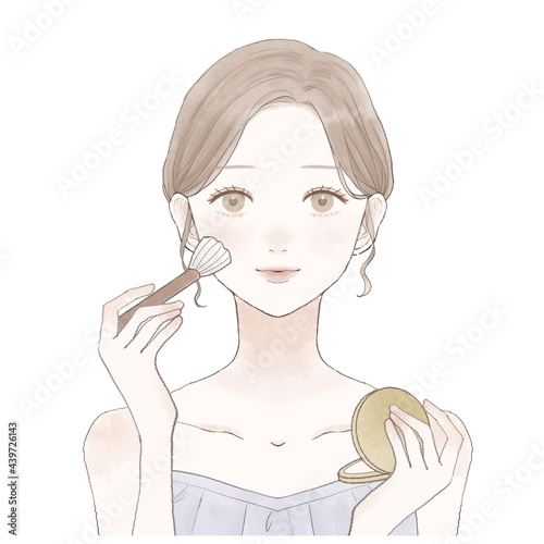 パウダリーファンデーションをメイクブラシで顔に塗る女性