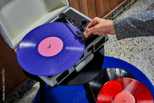 man about to play a violet disc in a turntable photo