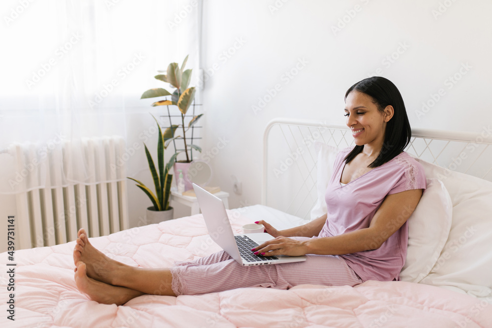 Morning routine. Woman drinking morning coffee and using laptop Morning routine. Woman drinking morning coffee and using laptop
