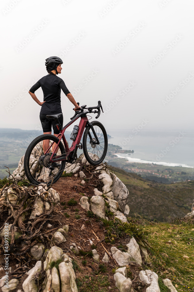Female cyclist on a gravel bike enjoying the forest view. Female cyclist on a gravel bike enjoying the forest view.