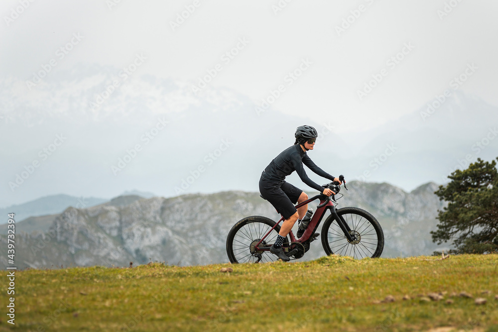 Sportive bicyclist working out on e bike in mountains Sportive bicyclist working out on e bike in mountains