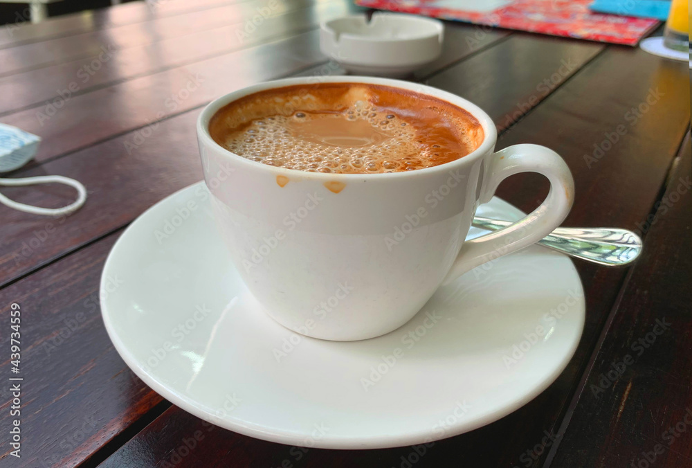 A cup of cappuccino in the morning on a wooden table A cup of cappuccino in the morning on a wooden table