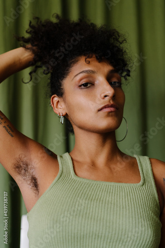 Black Woman with afro and armpit hair close up sitting on a white chair photo