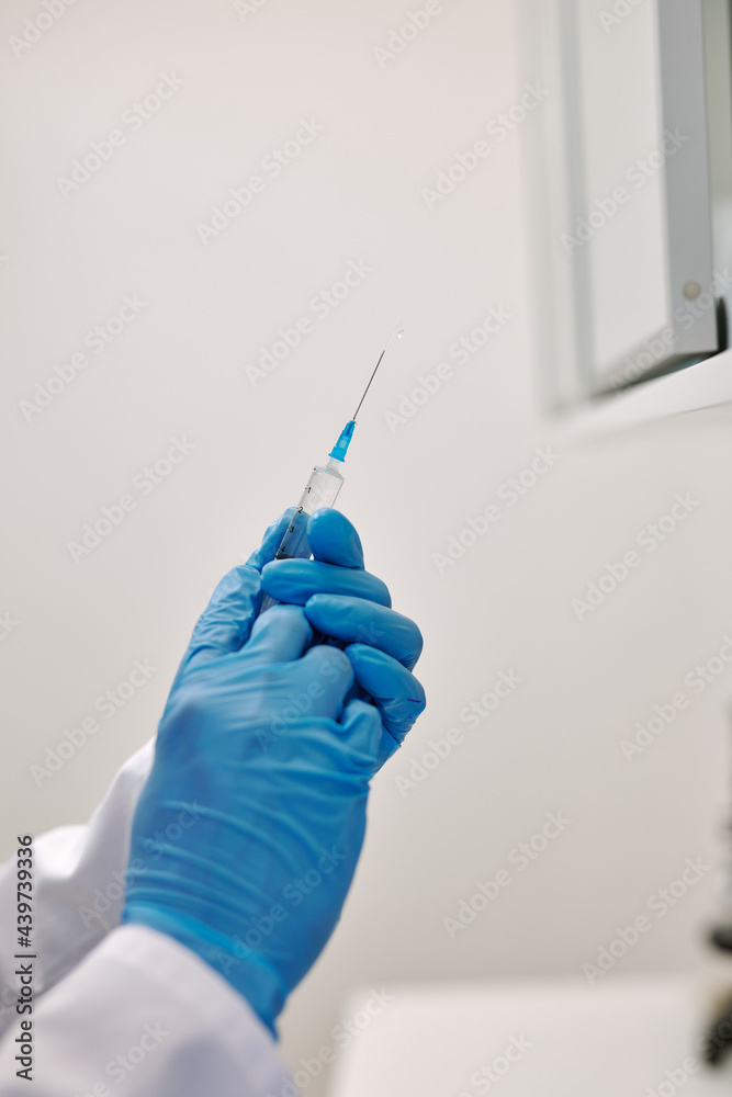 Physician holding syringe with flu vaccine Physician holding syringe with flu vaccine