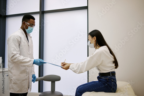 Doctor giving to client document for refer  photo