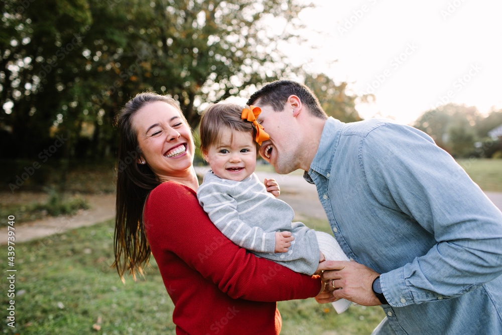 Young Mom and Dad Being Playful With Their Small Daughter Young Mom and Dad Being Playful With Their Small Daughter