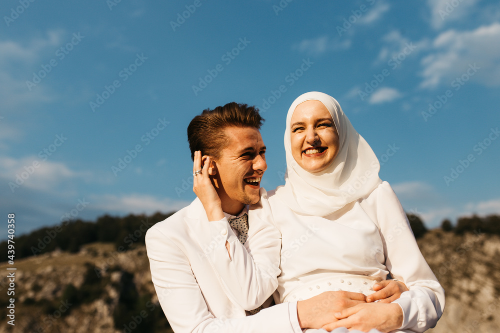 Happy Muslim couple sitting and laughing together Happy Muslim couple sitting and laughing together