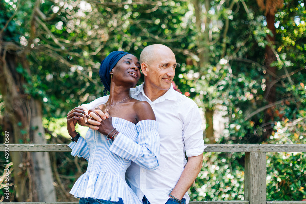 Happy diverse couple standing in embrace on terrace Happy diverse couple standing in embrace on terrace