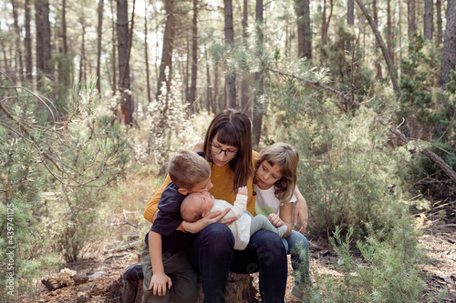 mother embracing her soons in a forest photo