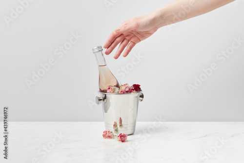 Girl taking bottle from ice bucket photo