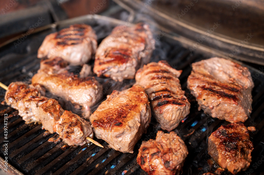 Steaks grilling on a gas barbecue.