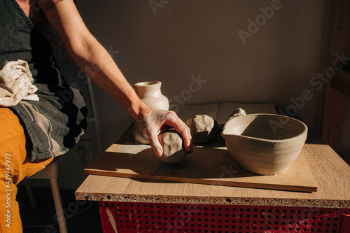 Hand of a potter taking a piece of clay for work