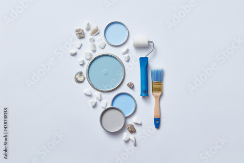 Blue lids of paints, paint roller and stones photo